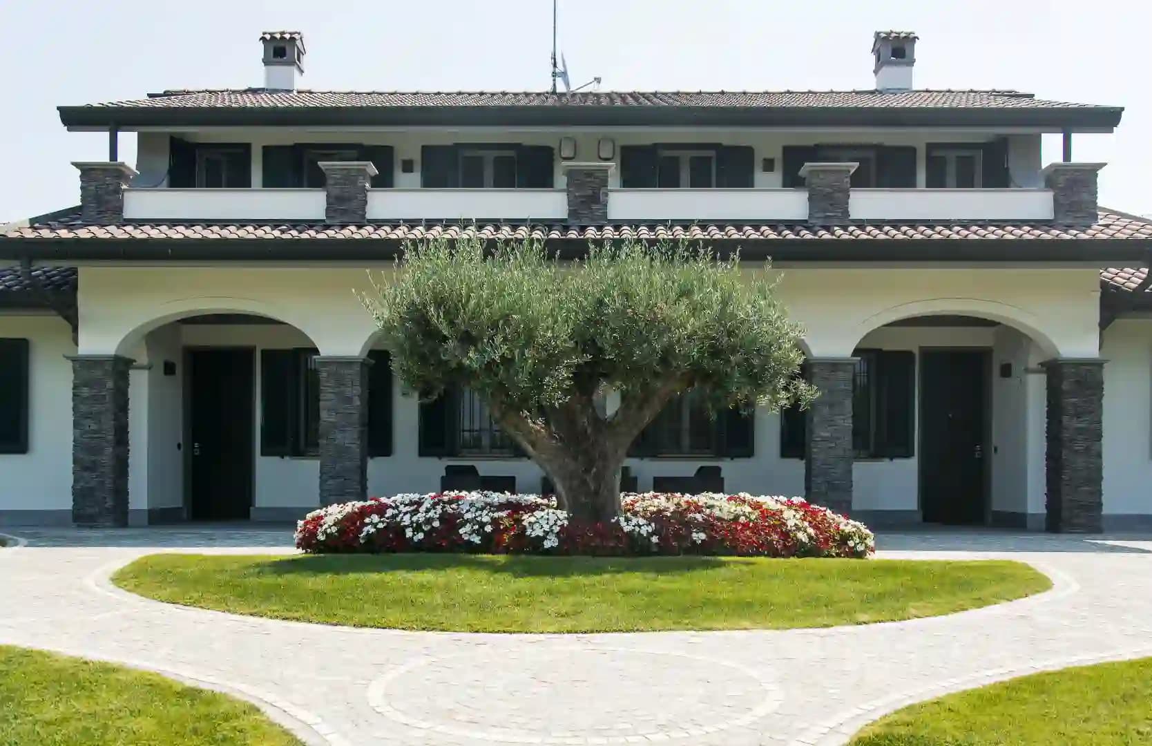 Giardino con grande villa e un prato curatissimo